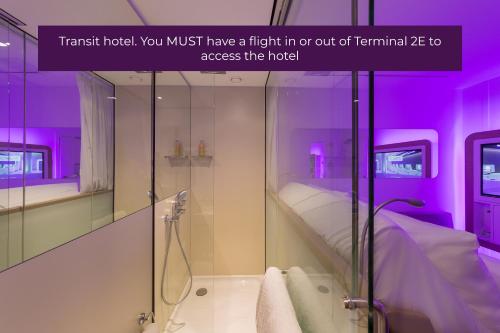 鲁瓦西昂法兰西YOTELAIR Paris CDG - Transit Hotel - Terminal 2E的浴室配有步入式淋浴间和紫色照明