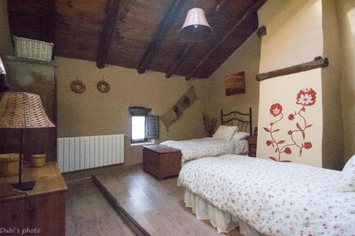 TamajónLa Casita de Leire的一间卧室设有两张床和木制天花板