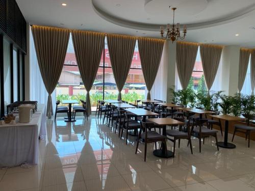 峇株巴辖Maple Lodge的用餐室设有桌椅和窗户。