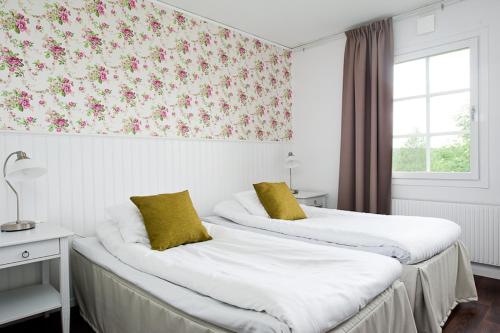 AlftaGästisbacken的两张位于酒店客房的床铺,配有花卉壁纸