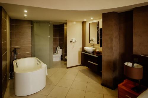 阿鲁沙SG Premium Resort的带浴缸、盥洗盆和卫生间的浴室