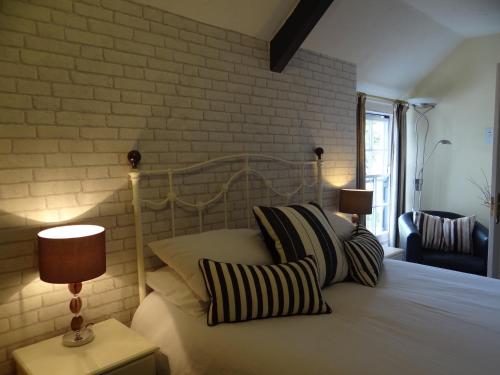 温福德顿德里酒店的一间卧室配有带枕头的床和砖墙