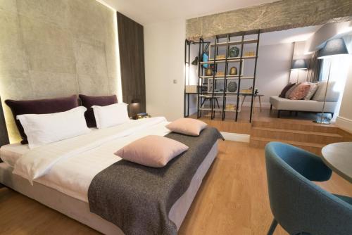 雅典47号豪华公寓的一间卧室配有一张大床和一张蓝色椅子