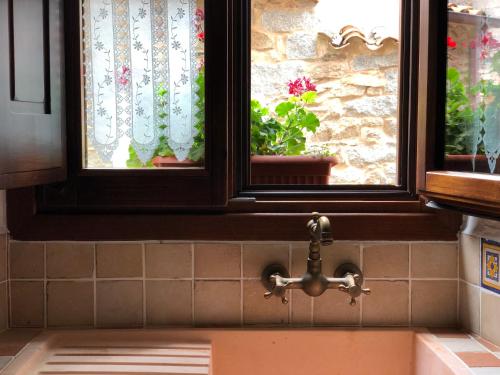 丰尼Casa Masini的带2扇窗户和水龙头的厨房水槽