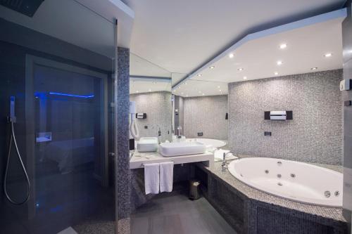 巴勒莫Ibis Styles Palermo Cristal的浴室设有2个水槽、浴缸和镜子