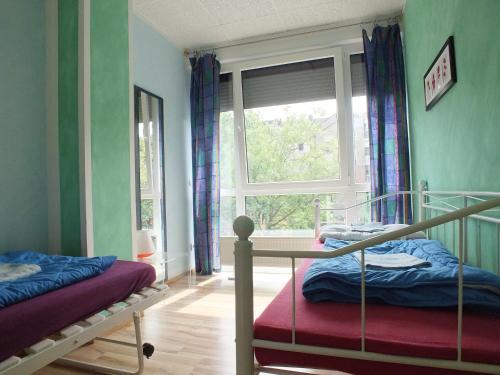 波恩马克斯旅舍的一间卧室设有两张双层床和一扇窗户。