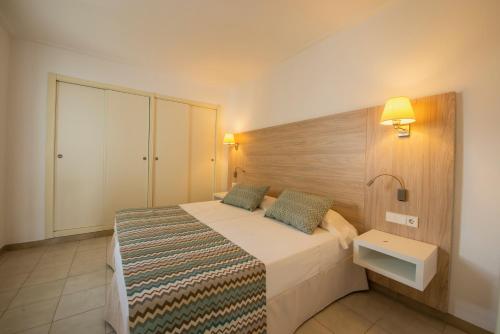 卡拉米洛Apartamentos La Santa Maria的一间卧室配有一张带木制床头板的床