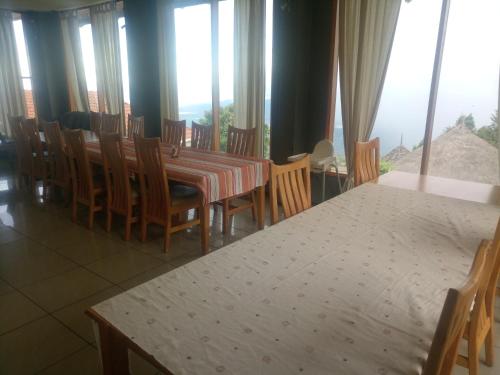 ItenKilima Resort的一间带桌椅和窗户的用餐室