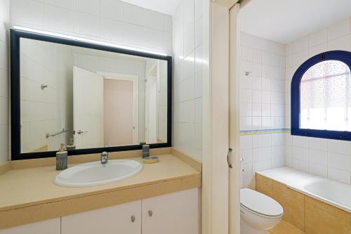 梅罗那瑞斯Bahía Meloneras Fase II的一间带水槽、卫生间和镜子的浴室