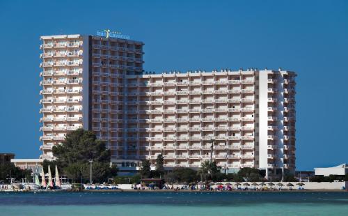拉曼加戴尔马尔梅纳Hotel Izán Cavanna的海滩旁一座大型建筑,前面有人