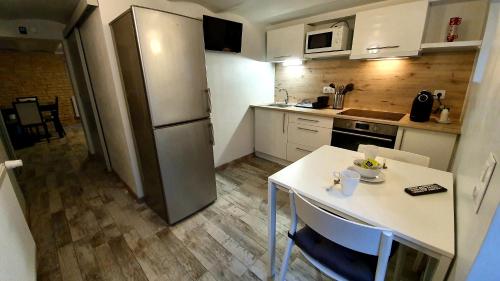 弗勒里莱欧布赖"LE TRAMWAY" Appartement 150m gare des Aubrais的一间带桌子和冰箱的小厨房