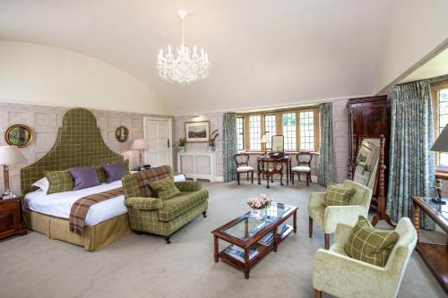 布罗德韦巴克兰庄园 - 瑞莱斯城堡酒店的一间卧室配有一张床铺、椅子和一张桌子