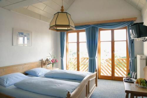 Neuler宾格兰德酒店的一间卧室设有两张床和大窗户