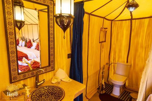 梅尔祖卡Tassili Luxury Desert Camp的黄色客房,配有床和镜子