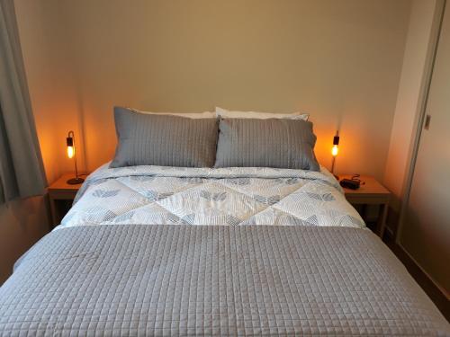 因弗卡吉尔South City Accommodation Unit 1的一间卧室配有一张床,两台桌子上放着两盏灯
