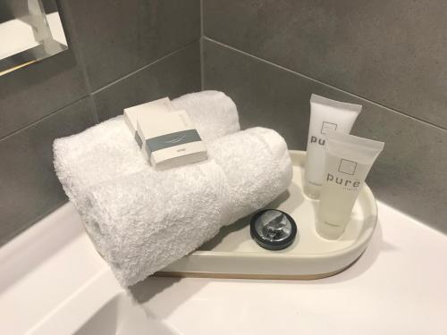 RisdonRisdon Brook Hotel的白色浴缸,配有毛巾和水槽上的体重秤