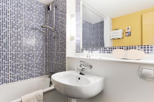 莱蓬德塞南昂热那桥基里亚德酒店的白色的浴室设有水槽、浴缸和水槽。