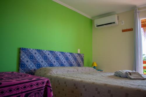 巴拉德瓦利扎斯Aparts Dunas de Valizas的一间卧室设有一张床和绿色的墙壁