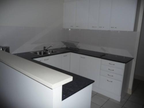 阿德莱德City Getaway 3 Bedroom Adelaide's East End的白色的厨房设有水槽和台面