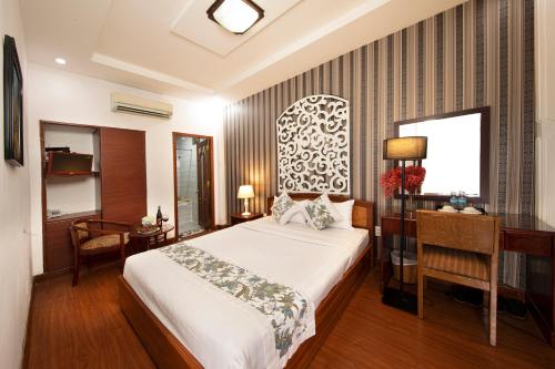胡志明市Vilion Central Hotel & Spa的卧室配有白色的床、书桌和窗户。