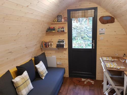 斯特拉西尔Strathyre Camping Pods的客厅设有蓝色的沙发和门。