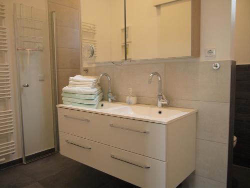 蒂门多弗施特兰德Strandperle 2的浴室配有盥洗盆、镜子和毛巾
