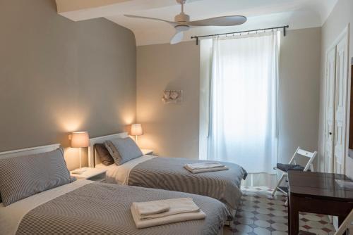 卢卡TERRAZZA COCCODE' spazioso con vista mozzafiato!的一间卧室配有两张床和吊扇