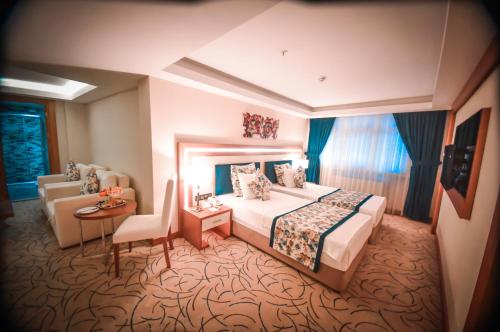 特拉布宗特拉布宗约斯假日酒店 的酒店客房设有床和休息区。