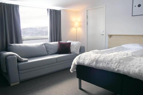 赫马万Hemavans Högfjällshotell的一间带沙发、床和窗户的卧室