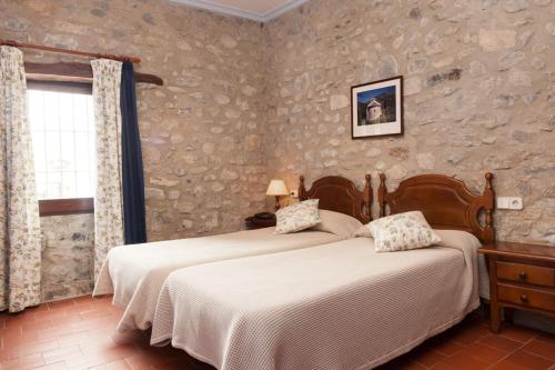 Oix德拉罗维拉旅馆的一间卧室设有两张床和窗户。