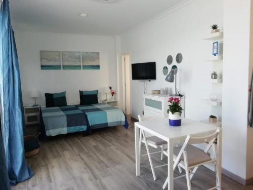 大加那利岛拉斯帕尔马斯Vista Canteras的卧室配有床和白色的桌椅