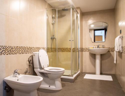 阿可贺巴Ottoman Signature Hotel的浴室配有卫生间、盥洗盆和淋浴。