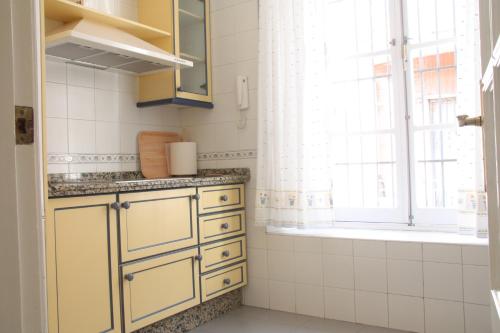 塞维利亚San Lorenzo en Esencia的厨房设有黄色橱柜和窗户。