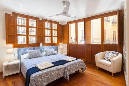 瓦伦西亚Apartamento Torres的一间卧室配有一张床、一把椅子和窗户。