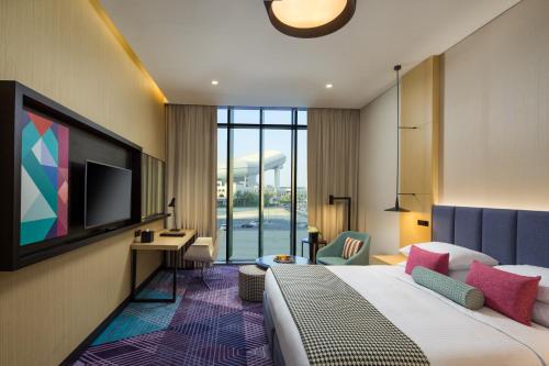 迪拜Millennium Al Barsha的酒店客房,配有床和电视