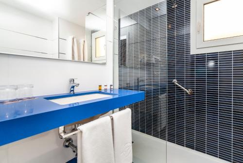 卡拉恩·布拉內斯Globales Binimar的浴室配有蓝色水槽和淋浴。