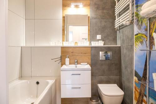 什切青Apartament Yooka的浴室配有盥洗池、卫生间和镜子。