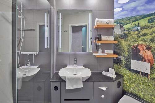 洛马尔纳法斯乡村酒店的浴室设有两个水槽,并画了一幅牛