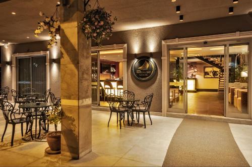 戈西克Hotel Marina Bay Göcek的一间在房间内配有桌椅的餐厅