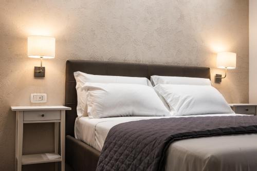 那不勒斯Prestige Rooms Chiaia的一间卧室配有带白色枕头和2盏灯的床。