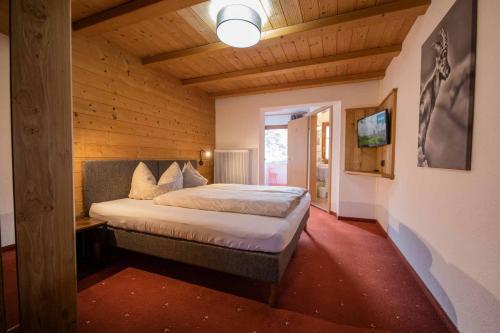 施图拜河谷新施蒂夫特Haus Steinbock的木制客房内的一间卧室,配有一张床