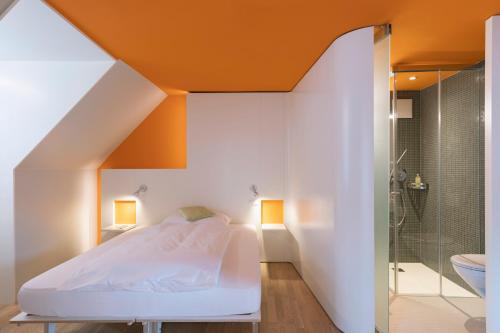 圣加仑多姆酒店的一间卧室设有橙色天花板、一张床和淋浴。