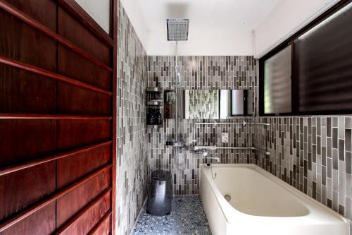 长崎Oyado Ryu / Vacation STAY 54218的带浴缸和瓷砖墙的浴室