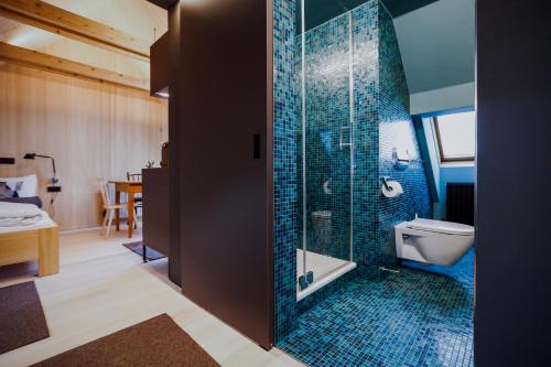 霍恩埃姆斯AUGUST Dachgeschosswohnung im jüdischen Viertel的浴室设有卫生间和蓝色瓷砖淋浴。