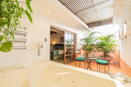 危地马拉安地瓜Hotel Museo Spa Casa Santo Domingo的带浴缸的客房内配有桌椅