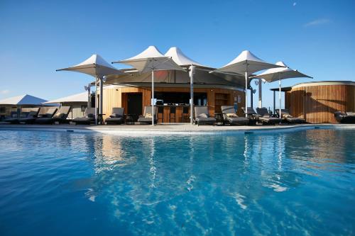 罗特内斯特岛Discovery Resorts - Rottnest Island的度假村内带椅子和遮阳伞的游泳池