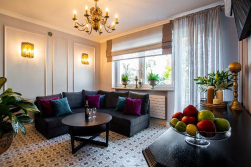 拉辛Apartamenty Willa Krakowska的客厅配有沙发和带一碗水果的桌子