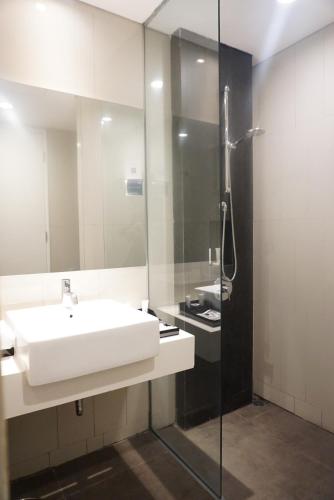 雅加达ARTOTEL Thamrin Jakarta的浴室配有白色水槽和淋浴。