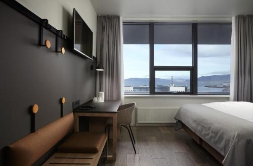 雷克雅未克卡宾酒店的酒店客房设有一张桌子、一张床和一个窗户。