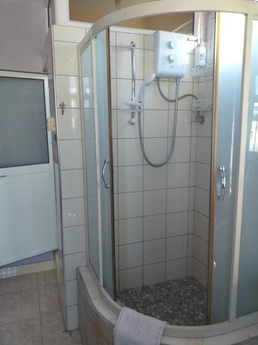 马埃堡提瓦博瑞宾馆的浴室里设有玻璃门淋浴